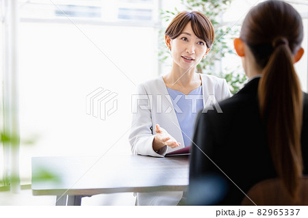 向かい合わせに座っているスーツを着た女性と会話するミドルの女性 向かい合わせに座っているスーツを着た女性と会話するミドルの女性 82965337