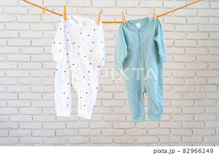 Washing of baby clothes pinned on a rope to dry Washing of baby clothes pinned on a rope to dry 82966249