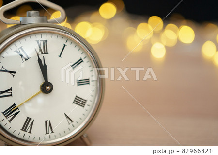 Close up of retro alarm clock on blurred Christmas background with bokeh Close up of retro alarm clock on blurred Christmas background with bokeh 82966821