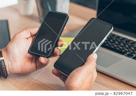 Man using mobile smart phone. Business man hands using cell phone at office desk. 82967047