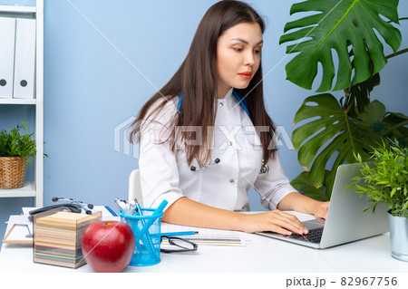 Young nice female doctor working in her office Young nice female doctor working in her office 82967756