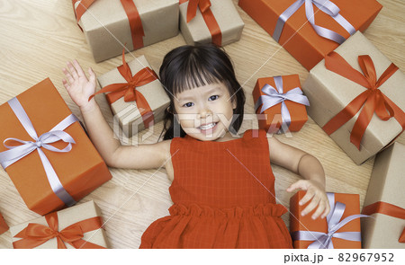 Portrait of little cute asian girl lying and playing on the floor with gift boxes, Christmas boxing day concept. asian small girl opening Christmas presents. Holiday toddler lifestyle concept.asian, b Portrait of little cute asian girl lying and playing on the floor with gift boxes, Christmas boxing day concept. asian small girl opening Christmas presents. Holiday toddler lifestyle concept.asian, b 82967952