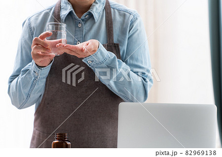 腹痛、体調不良で薬を飲む女性 82969138