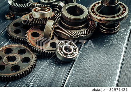Car parts gears and bearings on wooden background Car parts gears and bearings on wooden background 82971421
