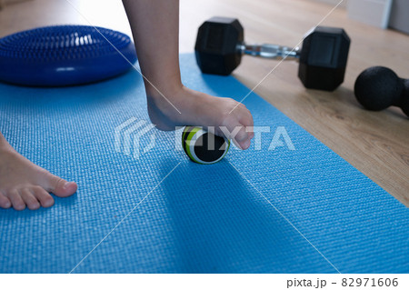Child foot rests on small gymnastic ball to massage feet closeup 82971606