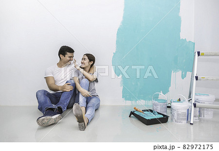 Portrait of happy smiling asian couple renovating painting wall house. Mother father repairing paint wall at home. Man and woman together love lifestyle concept with copy space. 82972175
