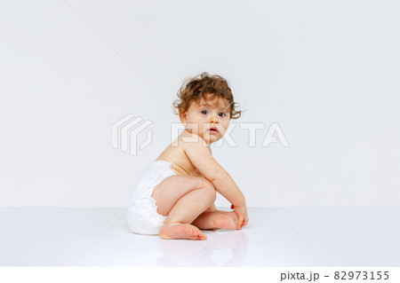 Portrait of toddler boy, baby in diaper isolated over white studio background. Family, happy childhood Portrait of toddler boy, baby in diaper isolated over white studio background. Family, happy childhood 82973155