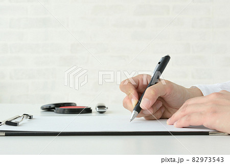 契約書にサインする人物の手 契約書にサインする人物の手 82973543