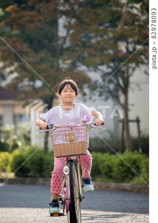 夏の住宅街で自転車を乗っている可愛い子供 夏の住宅街で自転車を乗っている可愛い子供 82978093