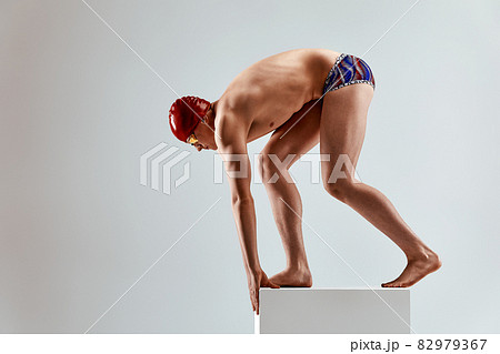 Portrait of a swimmer who is preparing for a jump. The concept of swimming and water games. Front view. Mixed media Portrait of a swimmer who is preparing for a jump. The concept of swimming and water games. Front view. Mixed media 82979367