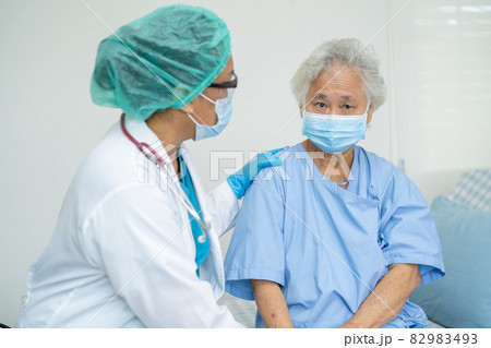 Doctor help Asian senior or elderly old lady woman patient wearing a face mask in hospital for protect safety infection and kill Covid-19 Coronavirus. Doctor help Asian senior or elderly old lady woman patient wearing a face mask in hospital for protect safety infection and kill Covid-19 Coronavirus. 82983493