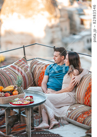 Happy young couple during sunrise watching hot air balloons in Cappadocia, Turkey 82983546