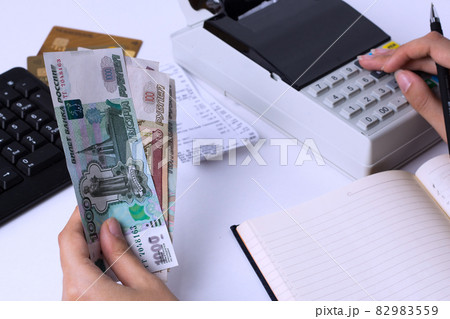 The issue of wages in Russia. Accountant cashier counts the money in rubles and fills the reports and statements. Office worker in the workplace. 82983559