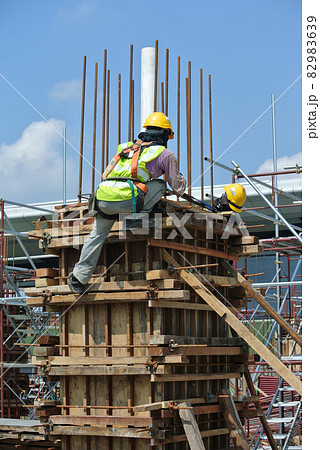 MALACCA, MALAYSIA -MARCH 25, 2016: Construction workers fabricating timber form work at the construction site in Malacca, Malaysia. The form work was mainly made from timber and plywood.  82983639