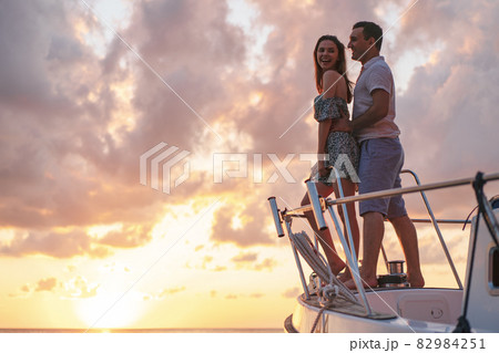 Beautiful couple looking at sunset from the yacht 82984251