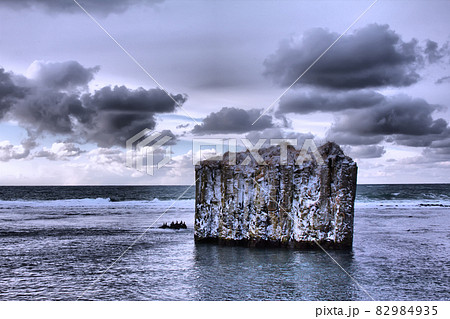 Pole in ocean. Rock with vertical walls. Basaltic parting, Pole in ocean. Rock with vertical walls. Basaltic parting, 82984935