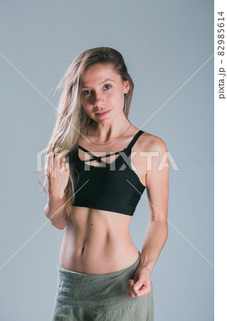Fitness girl with sporty body posing at studio on grey background. Fitness smiling model in sportswear. Weight Loss. Healthy lifestyle. Sporty healthy female. Fitness girl with sporty body posing at studio on grey background. Fitness smiling model in sportswear. Weight Loss. Healthy lifestyle. Sporty healthy female. 82985614