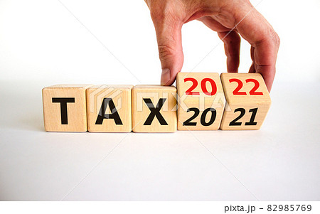 2022 tax new year symbol. Businessman turns wooden cubes and changes words 'Tax 2021' to 'Tax 2022'. Beautiful white background, copy space. Business, 2022 tax new year concept. 82985769
