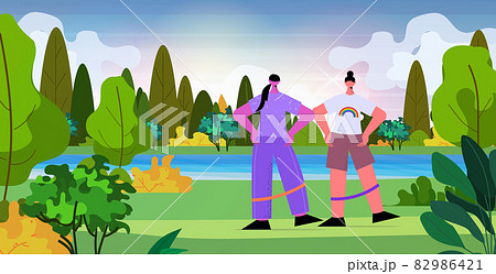 lesbian couple doing exercises with resistance band in park LGBT parade pride festival transgender love concept 82986421