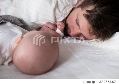 Sleeping father and cute child resting together in bed. 82986687