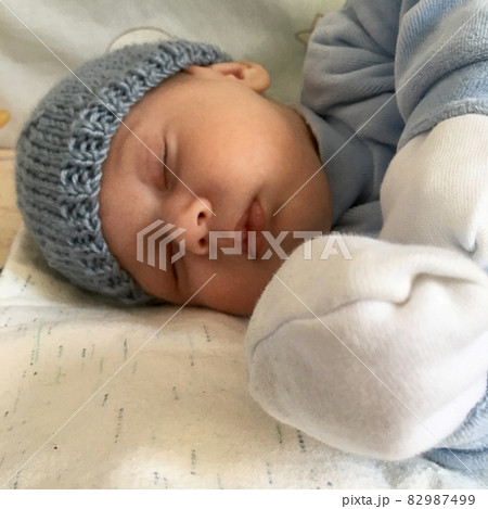 Beautiful sleeping baby boy with child hat posing photographer for color photo 82987499