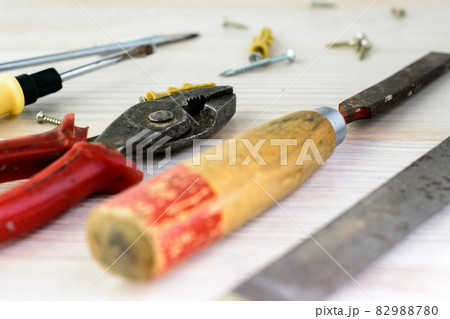 Repair tools on a wooden light background: file, pliers, pliers, screwdriver, screws, bolts 82988780