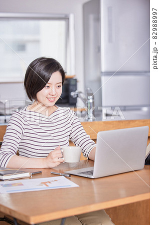 テレワーク中に気分転換にコーヒーを飲む若い女性 テレワーク中に気分転換にコーヒーを飲む若い女性 82988997
