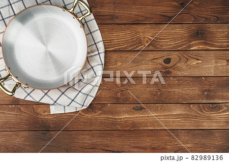 New copper cooking pot on wooden table, view from above 82989136