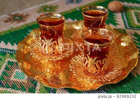 Three cups of black tea on golden oriental tray Three cups of black tea on golden oriental tray 82989232