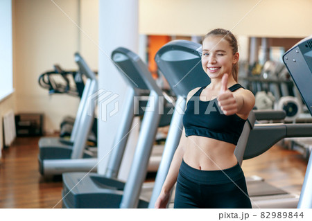 A young woman is engaged in fitness at the GYM. A woman on a treadmill. 82989844