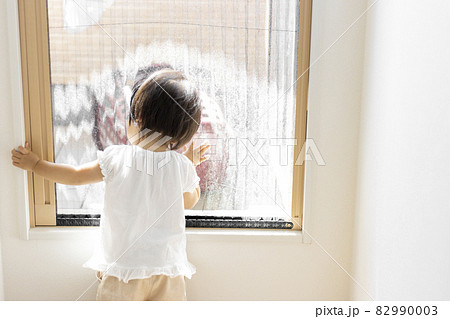 網戸から外をのぞき込む赤ちゃん(1歳2か月、日本人、女の子) 82990003