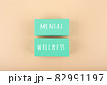 Mental wellness text written on aqua blue toy blocks on bright beige background 82991197