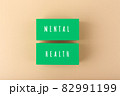 Mental health text written on green blocks on bright beige background 82991199