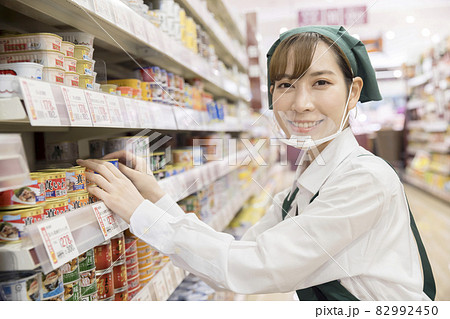 スーパーで商品管理をするマウスシールドをした女性従業員 82992450