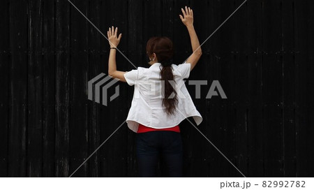 黒い壁に張り付く女性 82992782
