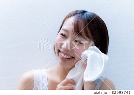 タオルで顔を拭く笑顔の女性 82998741
