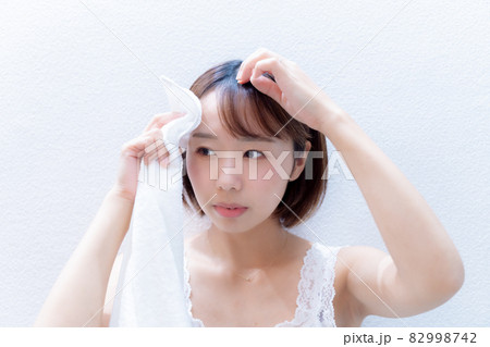 タオルでおでこを拭く女性 82998742