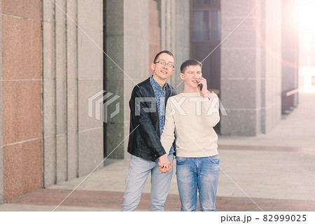 Cute gay couple in the city, tender gentle kissing, smiling Cute gay couple in the city, tender gentle kissing, smiling 82999025