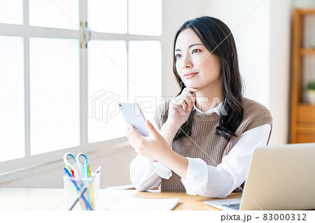 リビングでスマホを操作する女性 リビングでスマホを操作する女性 83000312