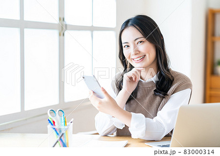 リビングでスマホを操作する女性 リビングでスマホを操作する女性 83000314