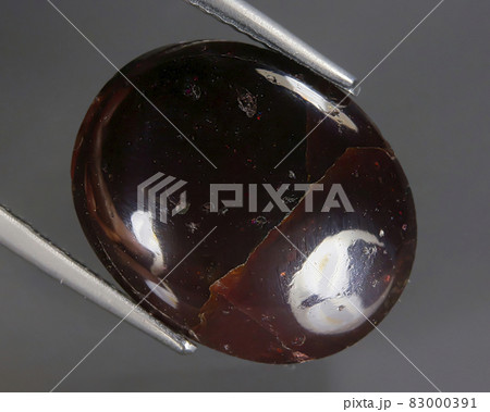 Natural almandine garnet on gray background Natural almandine garnet on gray background 83000391