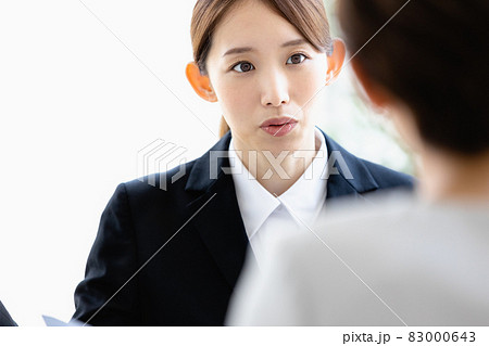 向かい合わせの人物と会話をする若い女性 向かい合わせの人物と会話をする若い女性 83000643