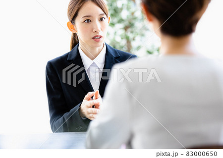 向かい合わせの人物と会話をする若い女性 向かい合わせの人物と会話をする若い女性 83000650
