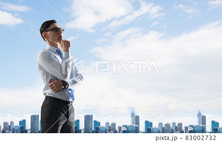 Concept of business success and control with confident boss against cityscape background Concept of business success and control with confident boss against cityscape background 83002732