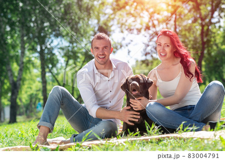 Couple with a dog in the park Couple with a dog in the park 83004791