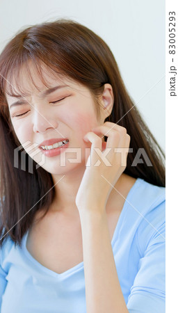 woman scratching her face 83005293