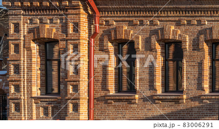 Three windows of the old mansion 19 century with brown bricks wall Three windows of the old mansion 19 century with brown bricks wall 83006291