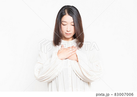 胸に手を当てて考え事をする主婦 83007006