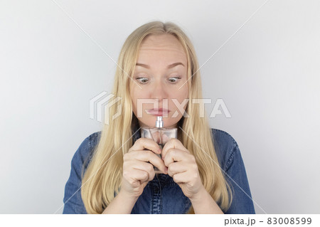 Loss of smell. Girl in front of the mirror sniffs the perfume and realizes that she does not feel it. Self-diagnosis covid-19. Symptoms of coronavirus. Quarantine and isolation. Test for sars-cov-2 Loss of smell. Girl in front of the mirror sniffs the perfume and realizes that she does not feel it. Self-diagnosis covid-19. Symptoms of coronavirus. Quarantine and isolation. Test for sars-cov-2 83008599