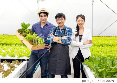 A guy and a woman farmer present on the farm with a smile and pride in their own start-up business in a hydroponic vegetable greenhouse with happiness and joy in the backdrop. A guy and a woman farmer present on the farm with a smile and pride in their own start-up business in a hydroponic vegetable greenhouse with happiness and joy in the backdrop. 83010079